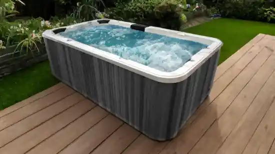 Modern outdoor swim spa with bubbling water and sleek grey cabinet on timber deck